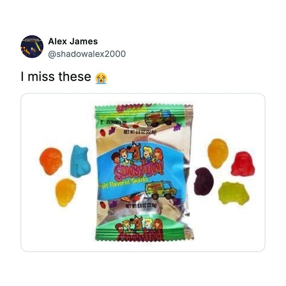 A classic pouch of Scooby-Doo! Fruit Snacks surrounded by translucent, colorful character-shaped gummies functions as a viral look at nostalgic snacks that defined school lunches in the 2000s.