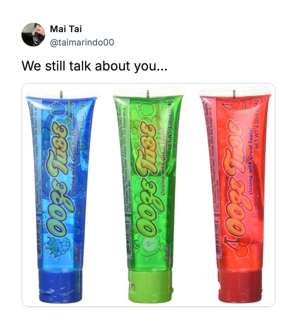 Three vibrant, colorful tubes of Ooze Tube liquid candy in blue raspberry, green apple, and cherry flavors serve as highly requested discontinued snacks on social media timeline updates.