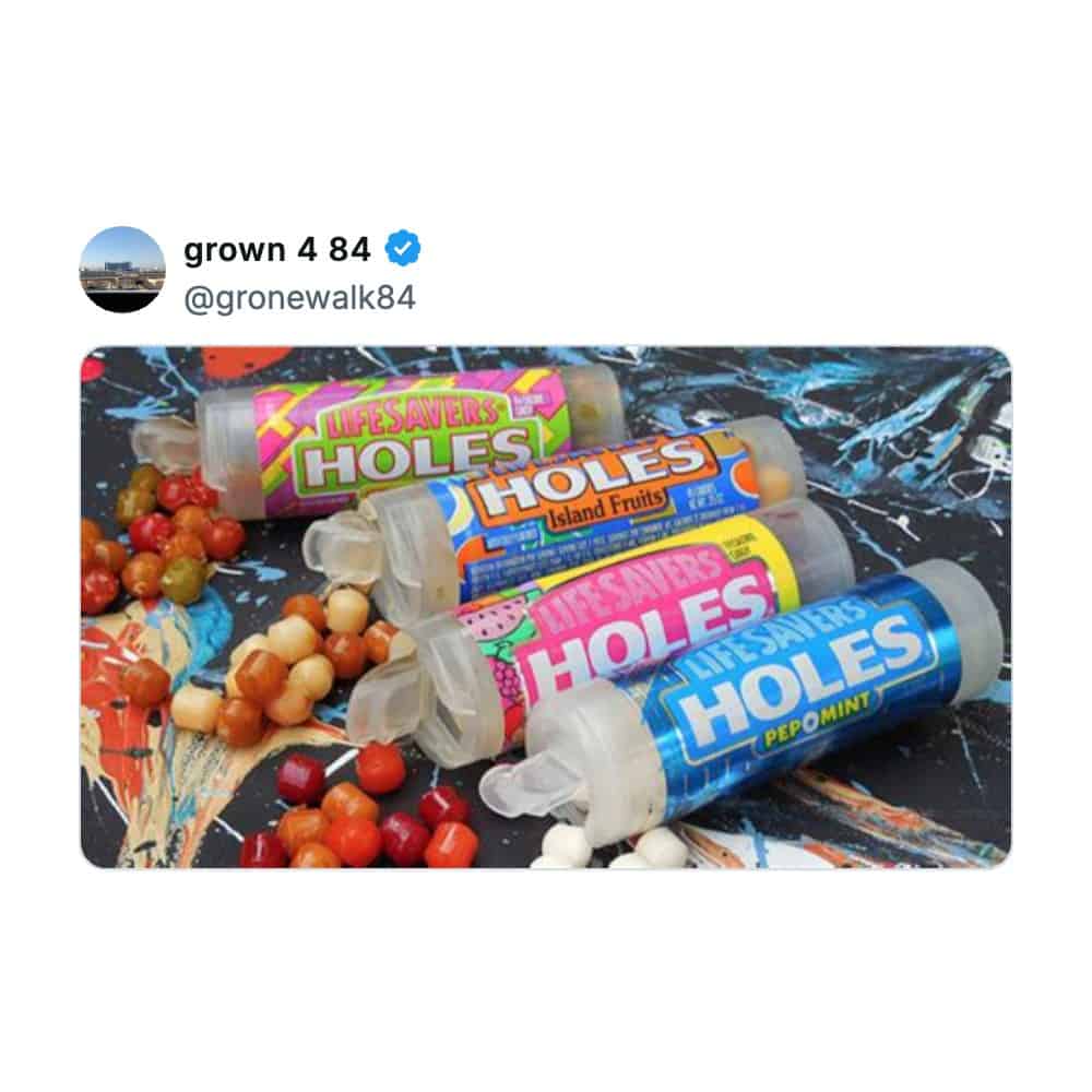 Four clear, cylindrical tubes of Life Savers Holes filled with tiny round candies highlight a tweet focusing on nostalgic snacks from the 1990s convenience store shelves.