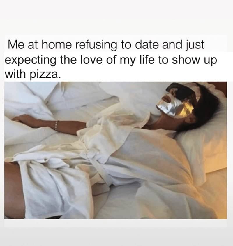 A woman wearing a silver face mask relaxing in bed, with relatable pizza dating text.
