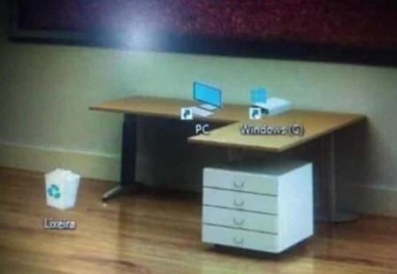 A desktop wallpaper that cleverly aligns computer icons with a picture of a physical desk and drawers.