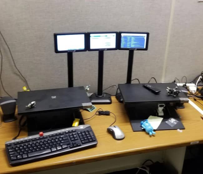 A triple monitor setup using three tiny, handheld-sized screens mounted on tall stands.