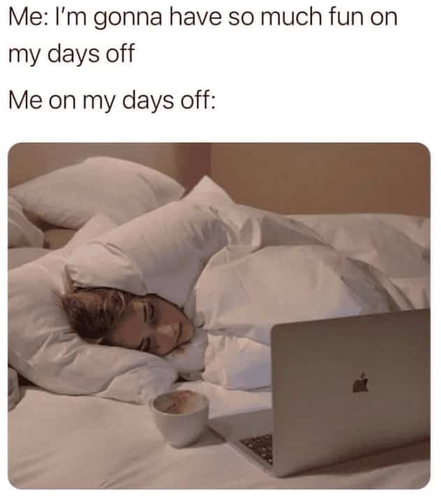 Woman buried under white duvet with laptop and coffee illustrating failed weekend plans.