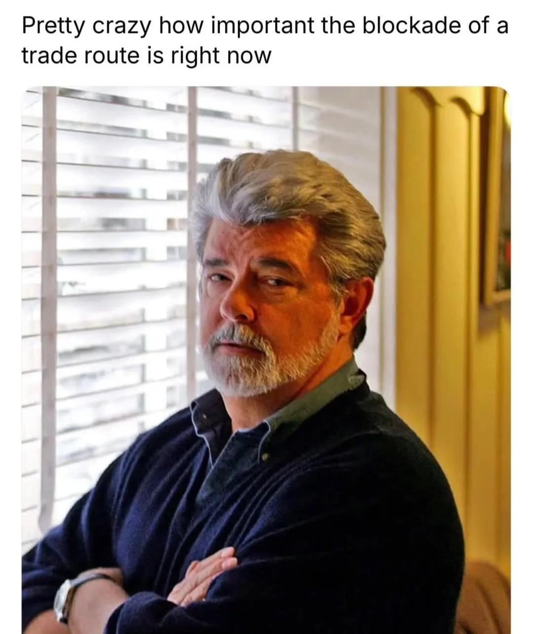 A portrait of George Lucas with text noting the real-world relevance of trade route blockades serves as a meta Star Wars meme. It connects the plot of The Phantom Menace to current global events.