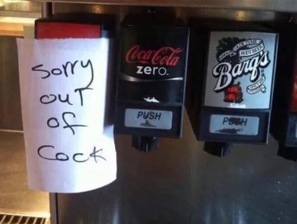 A handwritten note taped over a soda fountain dispenser nozzle creates an accidental, raunchy translation fail reading "Sorry out of Cock" instead of Coke right next to a Coca-Cola Zero tap.