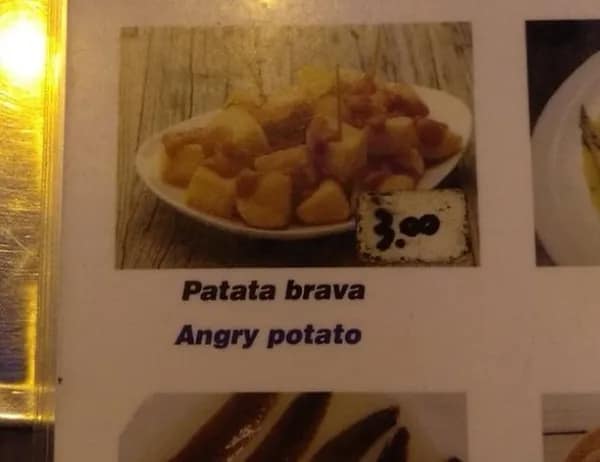 A restaurant menu entry for patatas bravas displays a highly amusing literal translation fail that rebrands the classic spicy Spanish potato tapa as an "Angry potato."