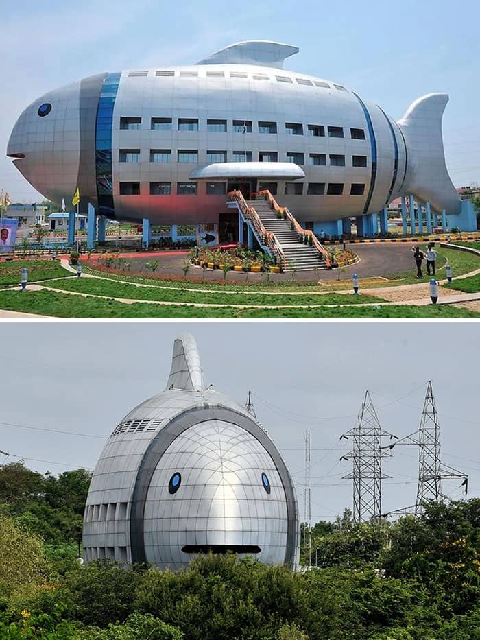A large office building shaped precisely like a giant silver fish with windows.