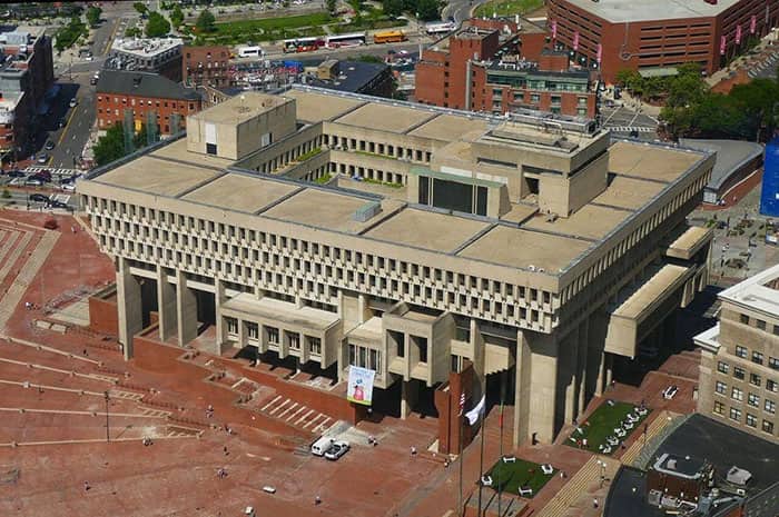 An aerial view of Boston City Hall showcasing its heavy, brutalist concrete architecture.