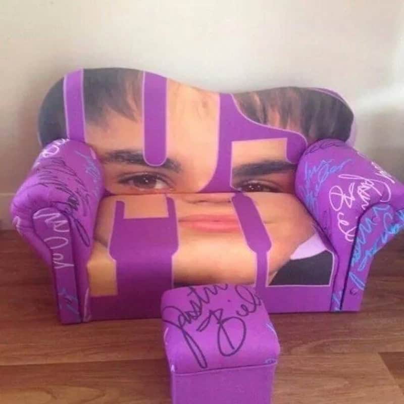 Purple children's sofa featuring a large, distorted print of Justin Bieber's face.