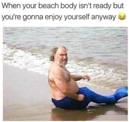 A pun-driven vacation meme showing a man sitting on a cooler directly on the sand while typing away on his laptop under the ironic bold caption, "I GO TO THE BEACH TO SURF."
