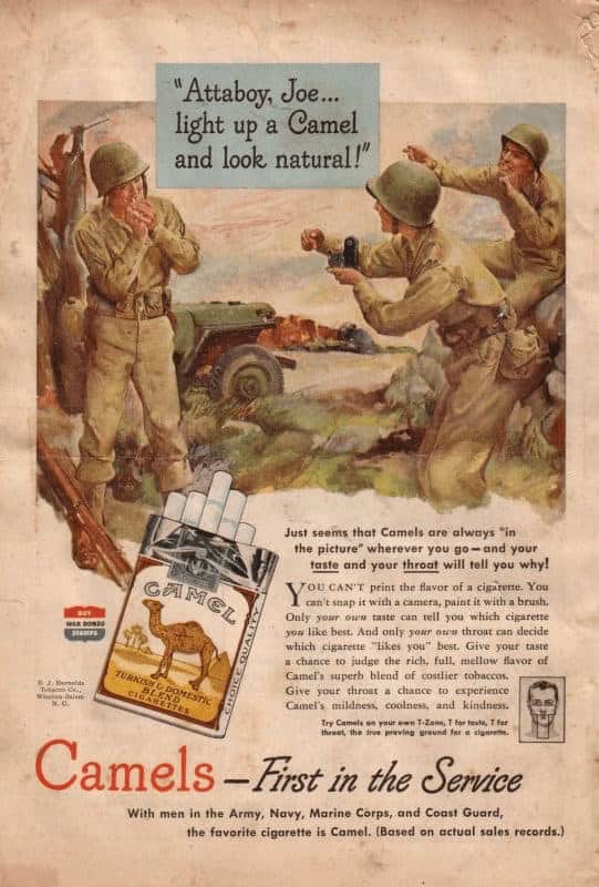 A wartime vintage cigarette ad for Camel showing soldiers in uniform in a field; one soldier uses a camera to snap a photo while telling his buddy to "light up a Camel and look natural!"