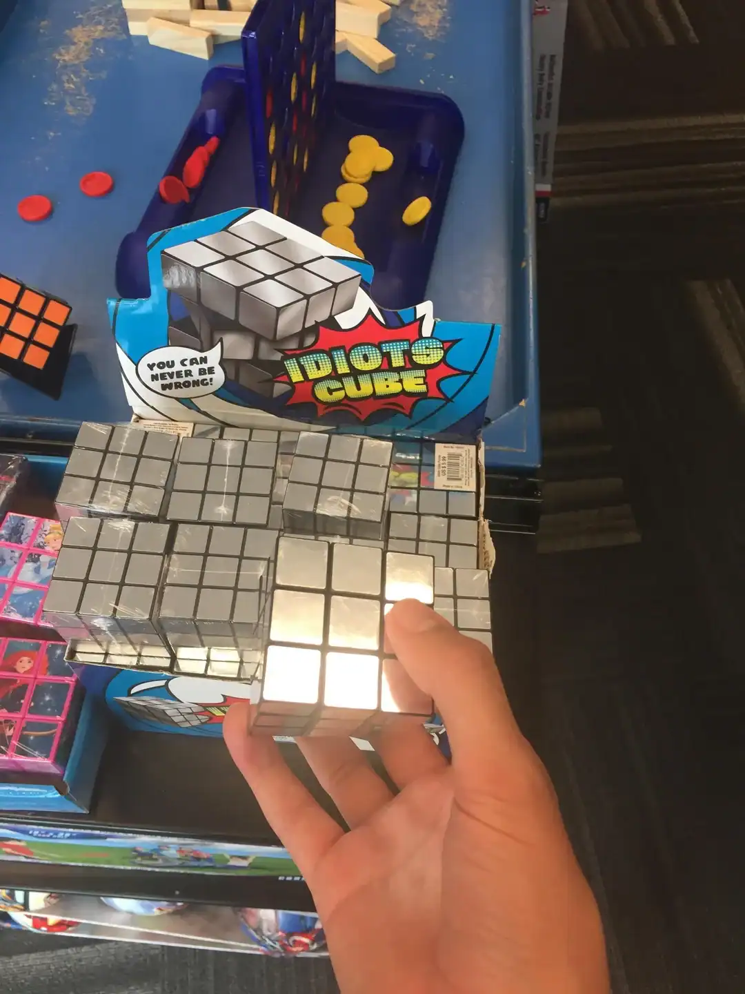 A parody weird product called the "Idiots Cube," a variation of a Rubik's cube where every single tile on every side is the exact same shade of chrome silver.