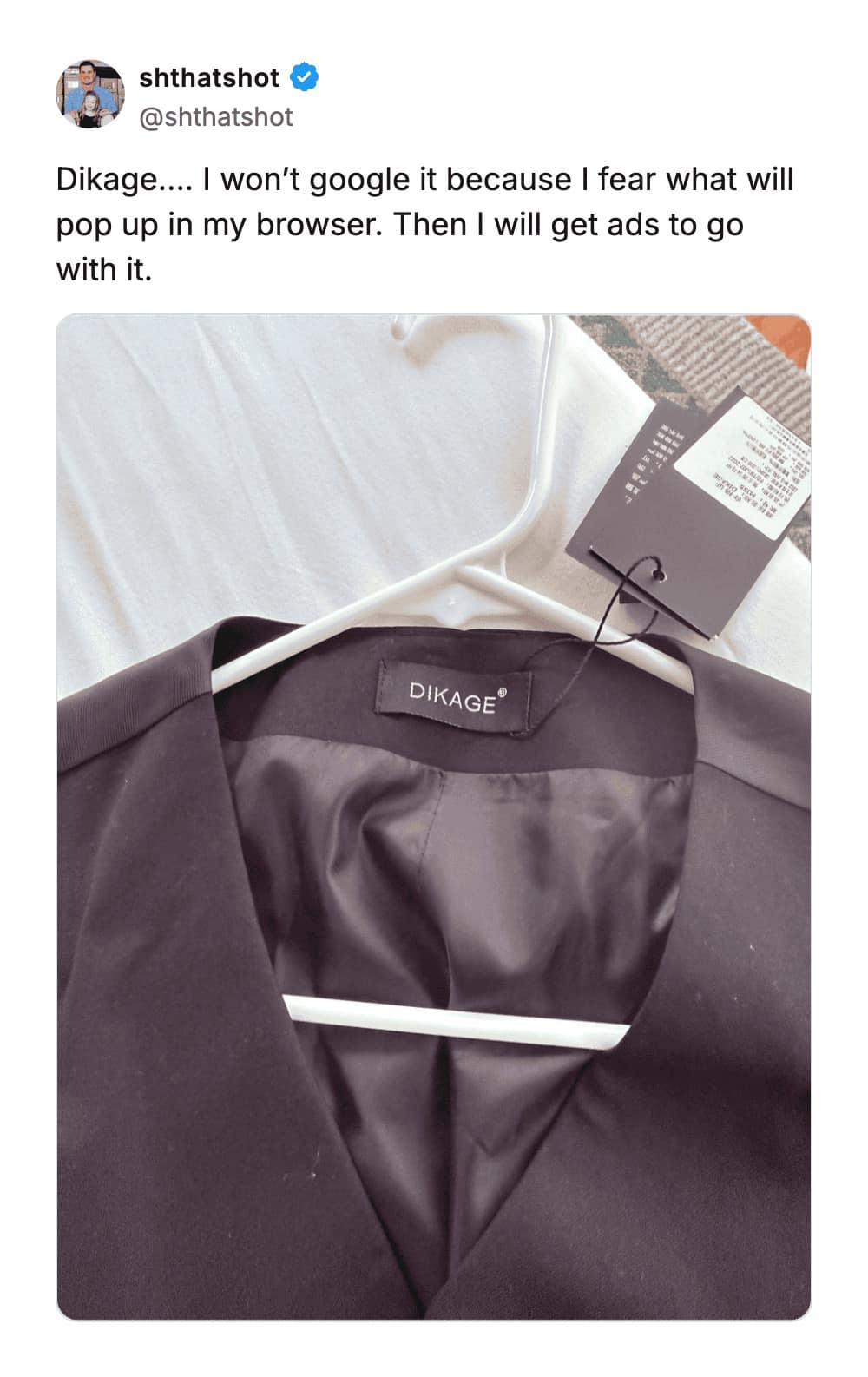 A close-up of a clothing label on a black vest featuring the brand name "DIKAGE," which stands as one of the worst business names for its unfortunate phonetic similarity to a suggestive phrase.