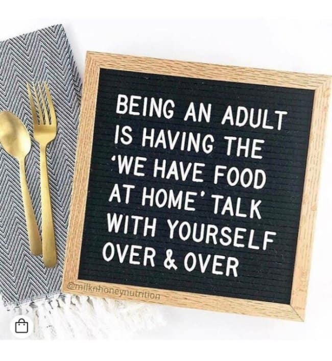 Letter board on a table says being an adult is having the “we have food at home” talk with yourself over and over, a classic adulting meme about becoming your own disappointed parent every time takeout sounds good.