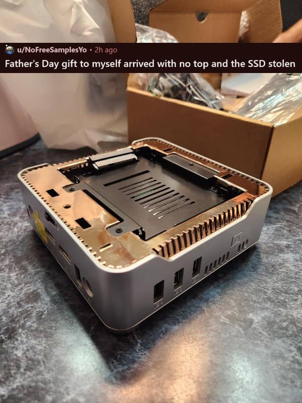 A mini PC casing sitting on a counter with its top panel missing and empty drive bay.