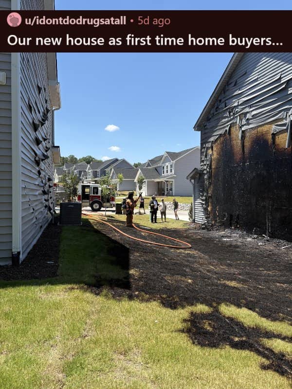 A residential neighborhood showing fire damage and melted vinyl siding on two adjacent houses.