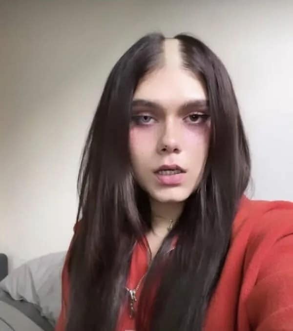 Woman with long dark hair featuring a completely shaved vertical line right down the center part, showcasing extreme bad haircuts.