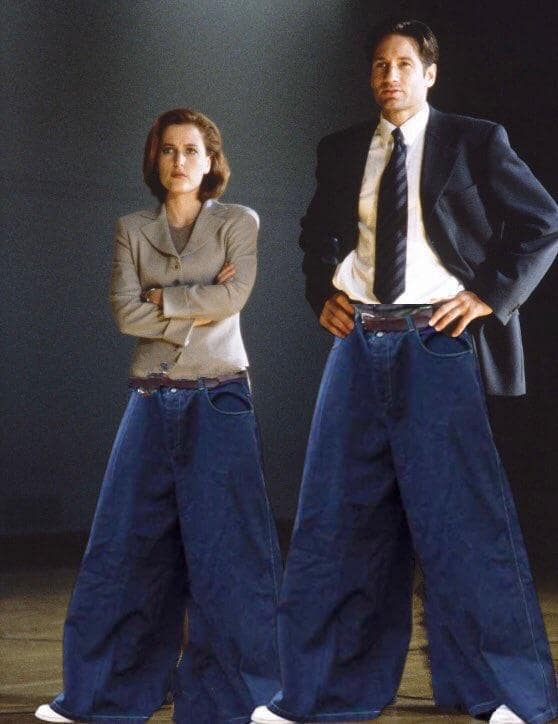 A classic meme pop-culture photoshop asset featuring Fox Mulder and Dana Scully from The X-Files looking completely serious while wearing absurdly massive, exaggeratedly wide-legged 90s style JNCO denim jeans.