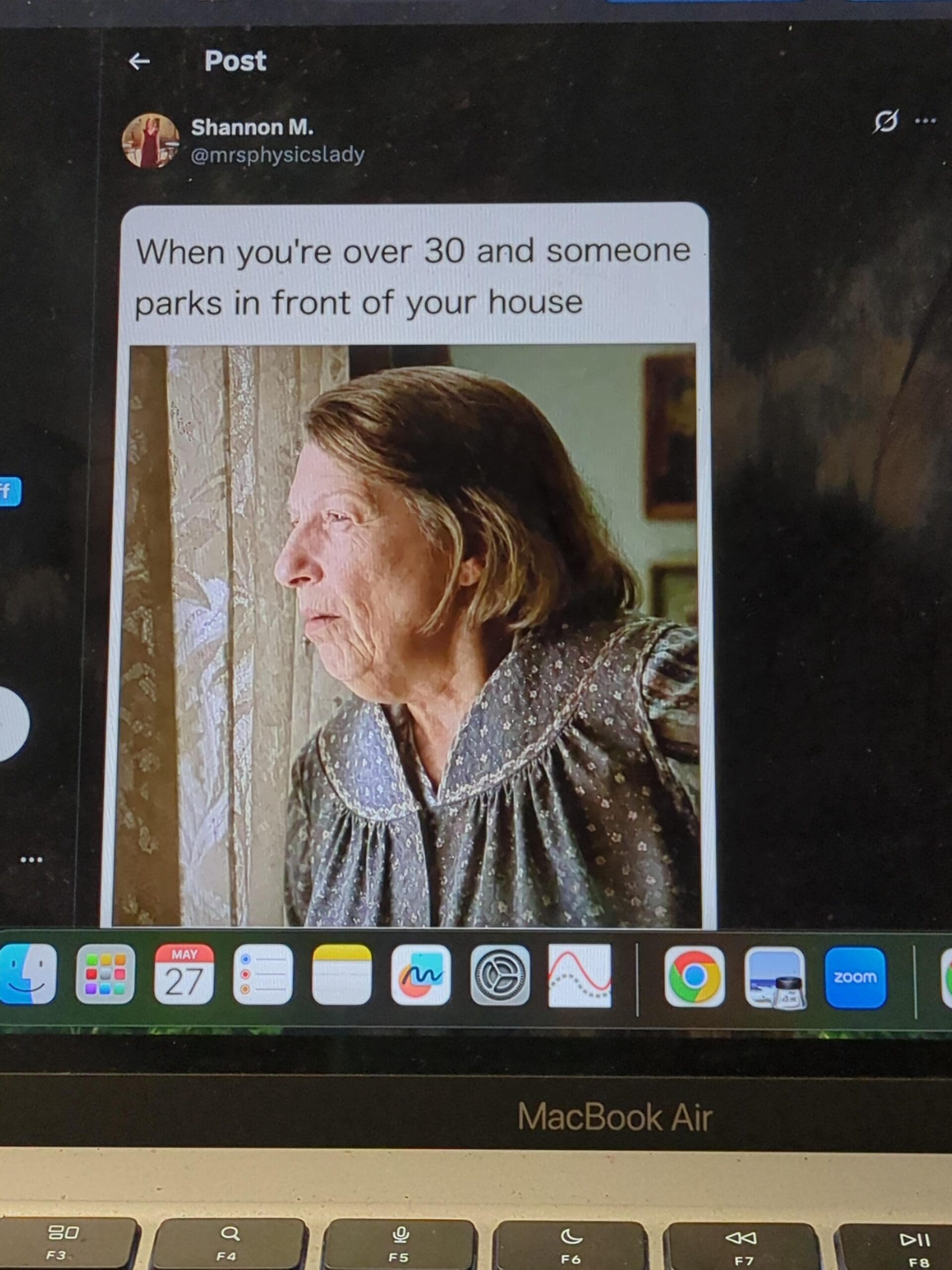 A laptop screen displaying a social media post about turning 30 and obsessively monitoring street parking, featuring an elderly woman peering intensely through window curtains in a classic meme.