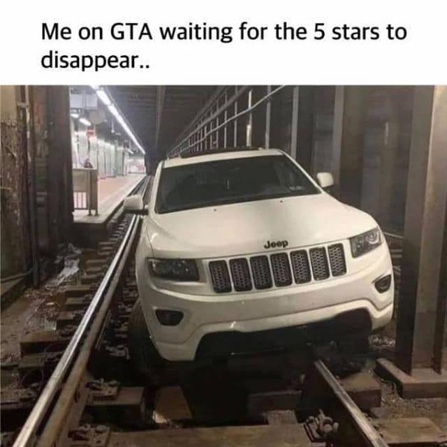 A classic meme gaming and travel mashup showing a white Jeep Grand Cherokee SUV completely wedged inside a tight subway train track tunnel, captioned above: "Me on GTA waiting for the 5 stars to disappear..".