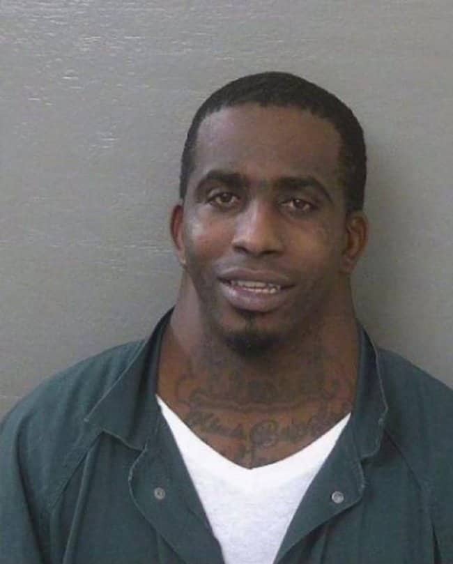 Mugshot of a smiling man with an incredibly wide and muscular neck.