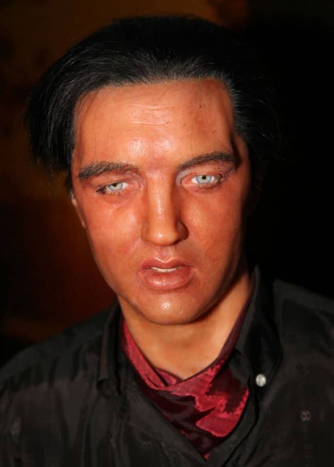 Close up headshot of a terrifyingly realistic, sweating wax figure of Elvis Presley.