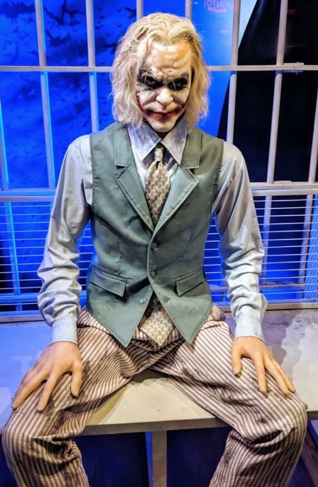 Creepy wax figure of Heath Ledger's Joker sitting inside a fake prison cell.
