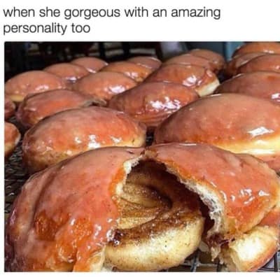 A mouth-watering donut meme showcasing rows of freshly glazed pastries on a bakery rack, with the foreground donut split open to reveal an entire cinnamon roll tucked hidden inside. The top text reads, "when she gorgeous with an amazing personality too."