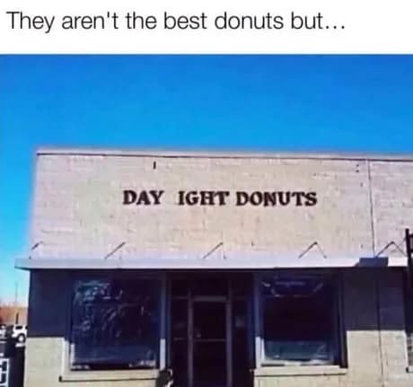 A funny real-world donut meme showcasing a brick bakery building where the storefront lettering has fallen off. Instead of reading "Daylight Donuts," it spells out "DAY IGHT DONUTS," turning it into a hilarious slang statement about the pastries being just "aight" (okay).