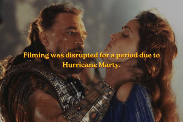 Agamemnon holding Briseis by the neck with a caption about Hurricane Marty disrupting production.