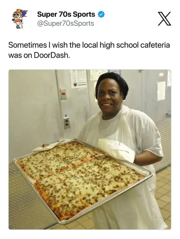 Food delivery meme showing a post wishing the local high school cafeteria was on DoorDash, paired with a cafeteria worker proudly holding a huge tray of cheesy rectangular pizza, invoking cafeteria nostalgia, industrial mozzarella, and childhood’s most elite square meal.