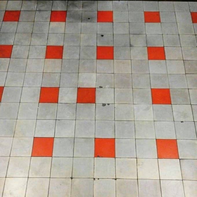 Disorganized floor tile grid pattern mistake with a misplaced red square out of alignment.