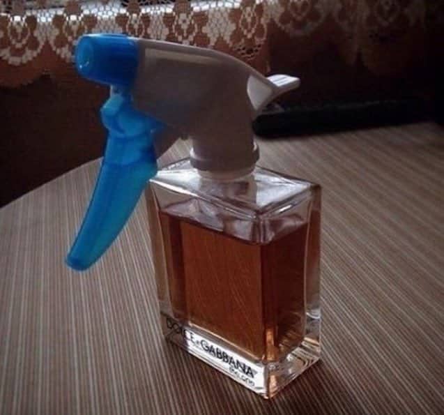 Impractical spray bottle nozzle attached to a glass container of designer Dolce Gabbana cologne.