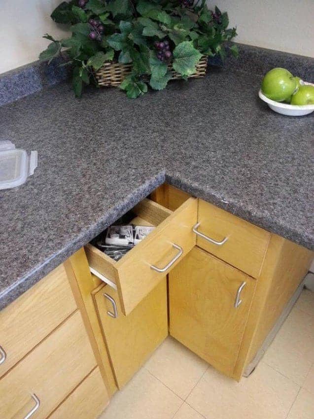 Poor kitchen design mistake showing a corner drawer blocking an adjacent cabinet handle from opening.