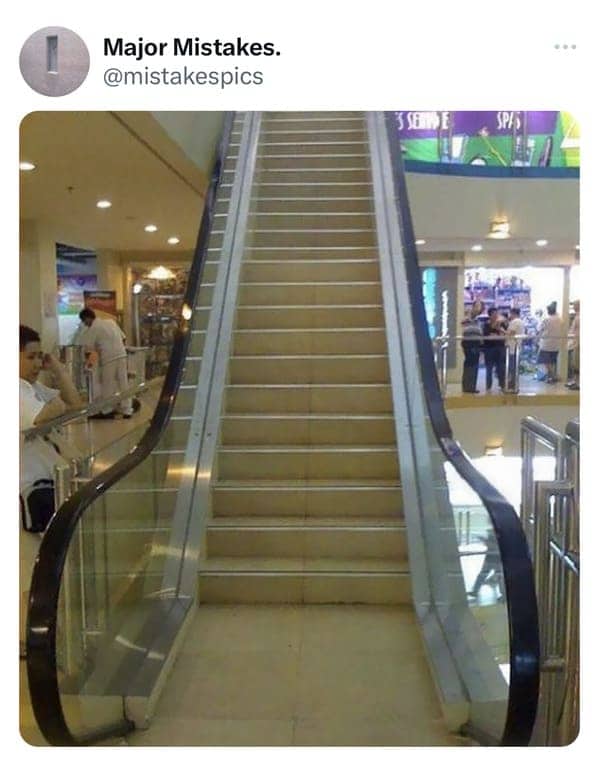 Bizarre mall architectural design fail showing an escalator feeding directly into a vertical concrete wall.