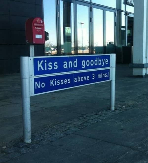 An airport sign that reads "Kiss and goodbye" and limits long goodbyes to three minutes maximum.