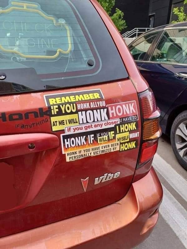 Pontiac Vibe covered in a confusing collage of overlapping bumper stickers about honking.