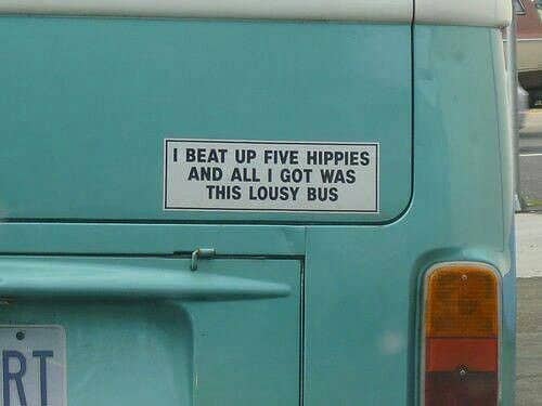Vintage blue Volkswagen bus featuring a cynical sticker about beating up five hippies.