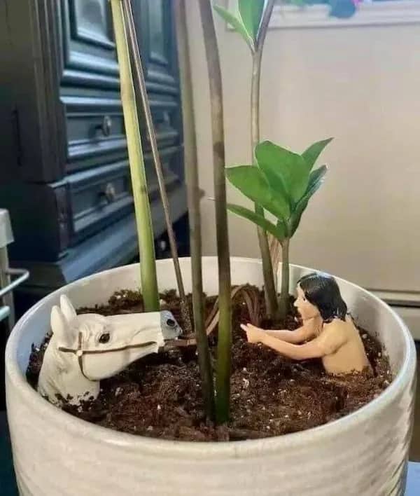 A creative houseplant pot decoration recreating the tragic Swamp of Sadness scene from The NeverEnding Story.