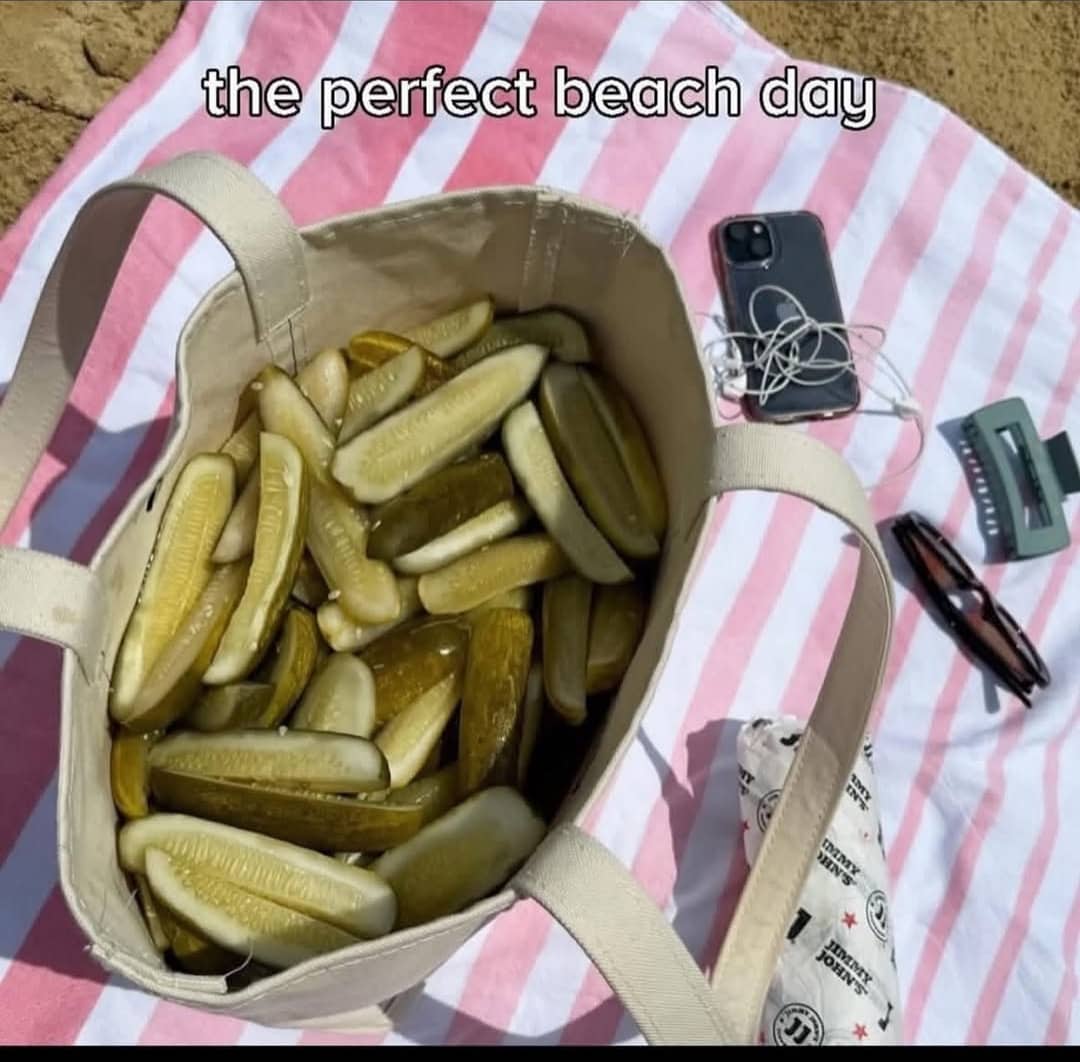 Canvas tote bag filled completely to the brim with green pickles on beach blanket meme.