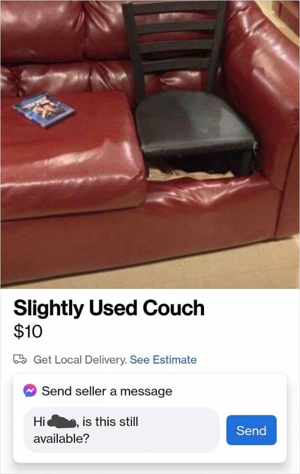 A red leather sofa with a black dining chair stuffed into a missing cushion slot.