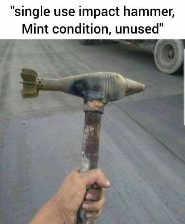 A rusty metal pipe welded to an unexploded military mortar shell labeled as a hammer.
