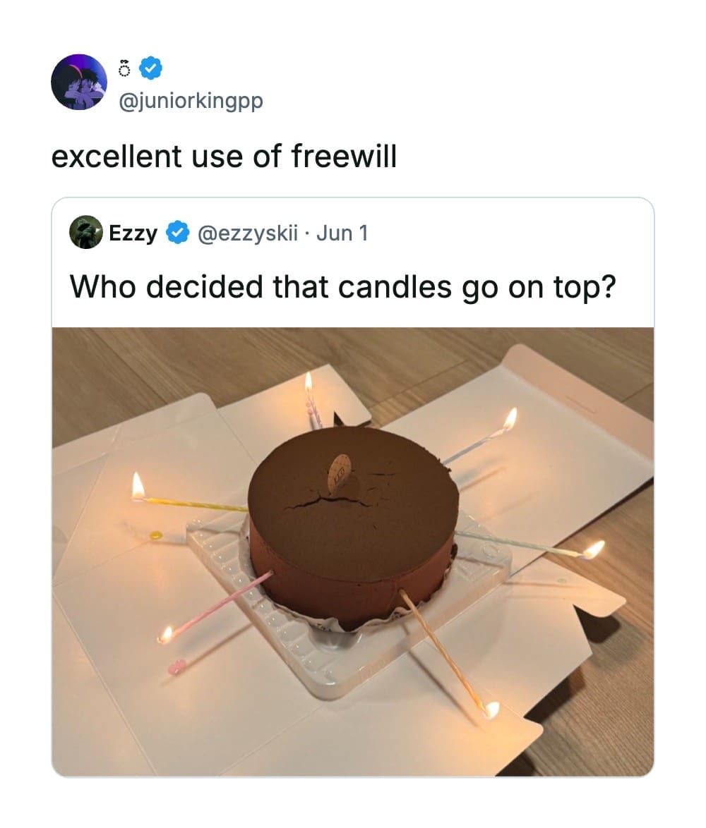 Round chocolate cake sitting on cardboard panels with long birthday candles pushed horizontally into its sides in a funny quote tweet by @juniorkingpp.