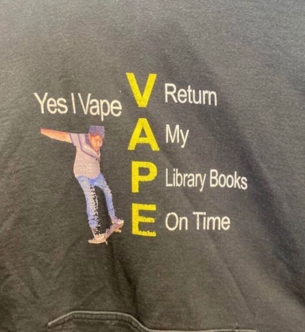 hilarious funny t shirt graphic featuring a chaotic, completely broken acronym layout that reads "Yes I Vape," vertically spelling out "V - Return, A - My, P - Library Books, E - On Time" next to a low-res image of a skateboarder.