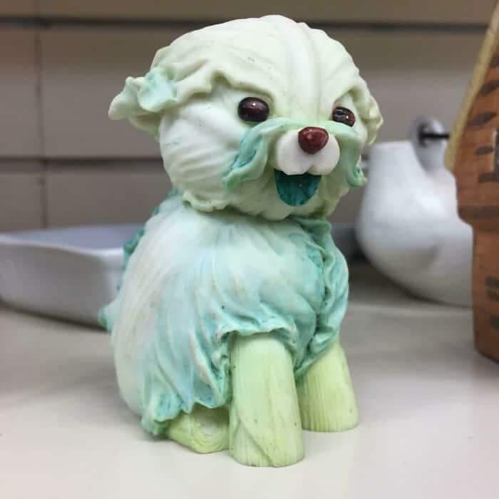 A disturbing decorative ceramic figurine salvaged as a funny thrift store find, shaped to resemble a small, fluffy dog but sculpted and painted so that the creature's entire body and fur are made out of pale green lettuce leaves.