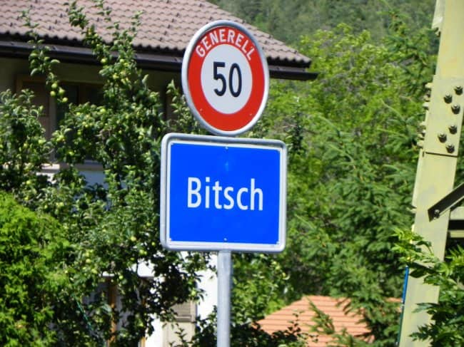 Blue European street sign marking the entrance to a town named Bitsch.