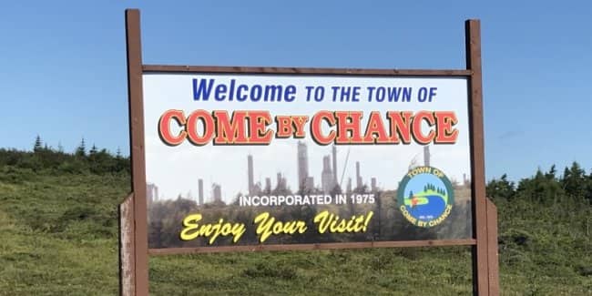 Large white welcome billboard for the town of Come By Chance.