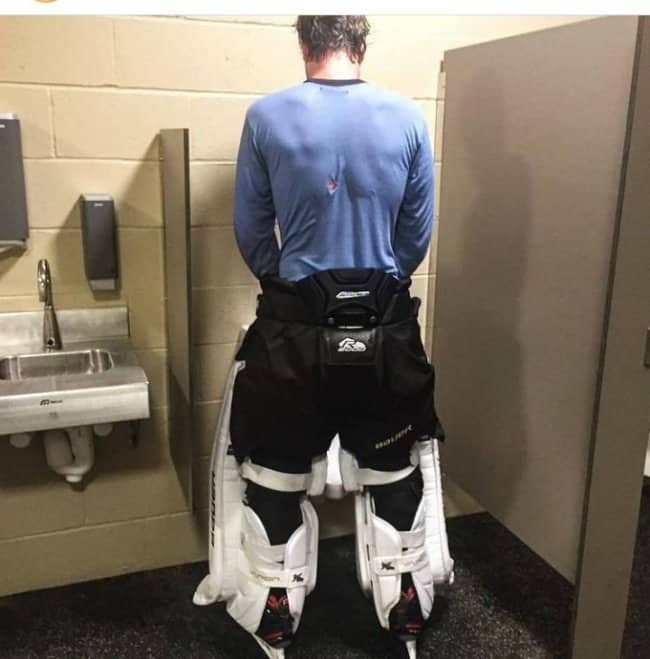 Funny hockey meme showing a goalie trying to navigate using a urinal while wearing full leg pads.