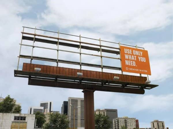Denver Water billboard showing an empty metal structure with a small orange message panel.
