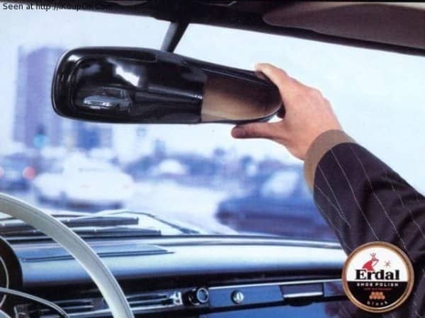 Shoe polish advertisement showing a highly reflective dress shoe used as a car mirror.